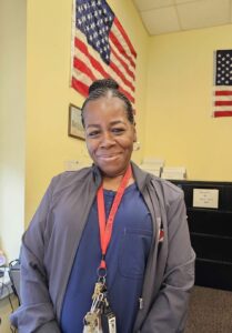 Nurse Thompson standing in her office smiling